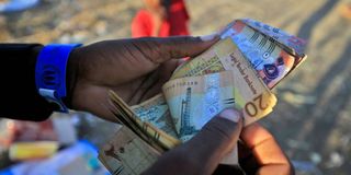 Ethiopian refugee counts money at Village 8 Sudan