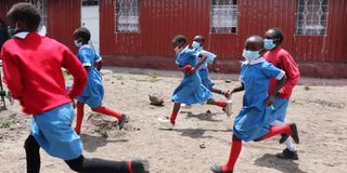 Learners run to class after break time at Star of Hope Primary in Industrial Area