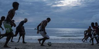 People play football at the Beau Fallon beach in Mahe island in Seychelles.