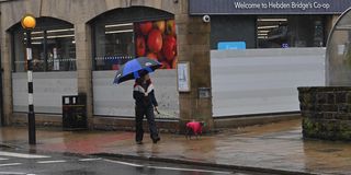 A pedestrian walks a dog in Hebden Bridge, northwest England on January 19, 2021.