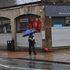 A pedestrian walks a dog in Hebden Bridge, northwest England on January 19, 2021.