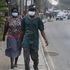 People walk along a main road wearing face masks in Lagos in February 2020.