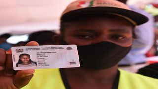 Catherine Wanjiku displays her Huduma Namba card at the Kiambu county commissioner's offices in November 2020.