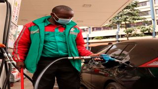 A filling station attendant fueling a car.