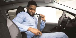A man wears his seat belt.