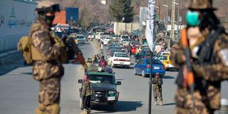 Taliban fighters stand guard