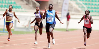 Maximilla Imali (centre) charges past her competitors in 100m semi-final heat 