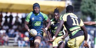 KCB's Davis Chenge attempts to beat Asumani Neugerwa and Alfred Orege of Kabras Sugar