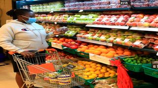 A woman buying foodstuffs in a supermarket.