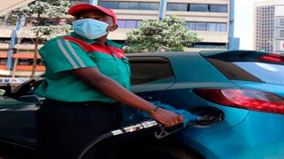 An attendant fuels a car at a filling station.