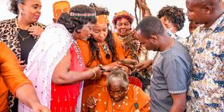 Mama Ngina Kenyatta shaves Field Marshall Mary Muthoni Wa Kirima'