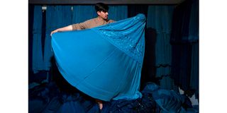 An Afghan vendor displays a burqa at his shop