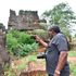 A local tourist takes a photo of the black rock at Chasimba Caves in Kilifi County.