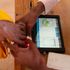 A polling clerk uses a Kiems kit to identify a voter at Wajir Girls High School.