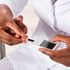 A doctor checks a patient's sugar level with a Glucometer. 