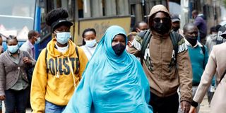 People wearing masks walk in a Nairobi street.