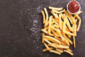 French fries with ketchup on a dark table.