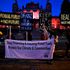 Climate activists hold illuminated signs and a banner protesting against the use of fossil fuels