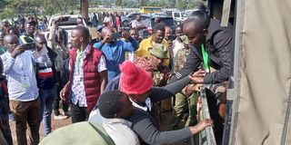 Police arresting a lady who is alleged to have edited a form 34 A at Nasokol girls school Kapenguria constituency on 10/9/2022