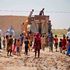 People collect water from a cistern in al-Aghawat, Iraq