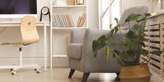 Background image of comfy grey armchair in a cosy nook of a modern Scandinavian home.