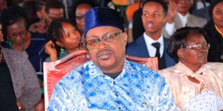 Mr Dennis Apaa follows the proceedings of Embu Governor Cecily Mbarire's swearing-in.