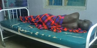 A patient sleeping on a torn mattress at Lodwar County and Referral Hospital