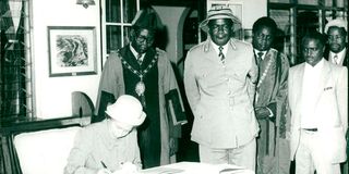 Queen Elizabeth II signs the visitor's book at Nyeri Club during a visit to Kenya.