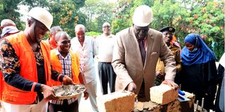 Education Cabinet Secretary Prof. George Magoha puts a Construction Block at Bomu Secondary School.