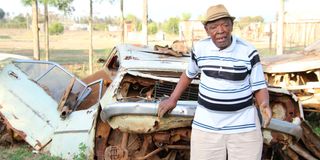 Andrew Githinji inspects the wreckage of his car outside a compound at Gwathamaki village in Nyeri county.