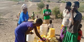 Residents of Kawalase village queue to fetch water on September 19, 2022