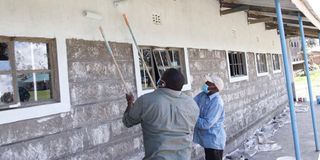 Workers apply paint on a newly built classroom in Elburgon.