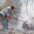 Mzee Mutua Mangeli, a volunteer firefighter, combs a charred section of Kitondo Forest in Makueni County