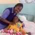 Elizabeth Robai Lukresia, a second year pediatric student nurse at Kenya Medical Training College (KMTC) with a child patient