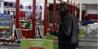 A man walks past a Lipa Na M-Pesa counter at a supermarket in Nairobi.