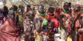 Members of the public wait for their rations of relief food