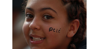A child waits for the start of the wake for Brazilian soccer legend Pele