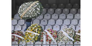 A man carries a flower wreath inside Vila Belmiro stadium during Pele's wake