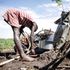 A child cooks outside her home in Kisumu