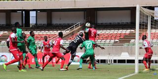Kenya Police goalkeeper Job Ochieng (in black) vies for an aerial ball 