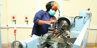 A mechanical engineering student operates a lathe machine at Nyeri National Polytechnic