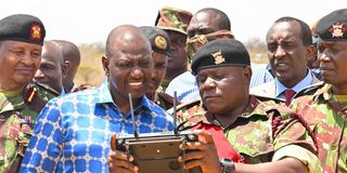 President William Ruto is shown how a drone is operated during the opening of the Border Police Hospital in Kanyonyo, Kitui