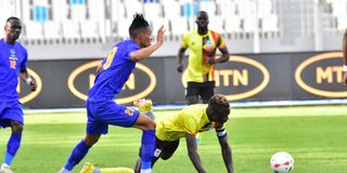 Uganda captain Emmanuel Okwi (right) is tackled by a Tanzanian player