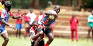 Eliude Kiyayi of Ofafa Jericho Secondary School is tackled by Gregory Mogire of Lenana School