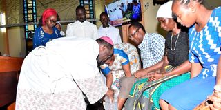 Archbishop Martin Kivuva washes the feet of Catholic faithful