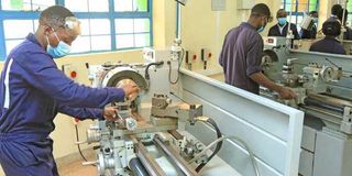 A mechanical engineering student operates a lathe machine at Nyeri National Polytechnic