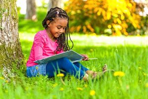 A girl reading under a tree