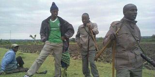 Men armed with bows and arrows stand guard in their village in Pimbinyiet, Narok County