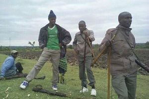 Men armed with bows and arrows stand guard in their village in Pimbinyiet, Narok County