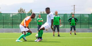 Moses Shumah (left)vies for the ball with Amos Nondi